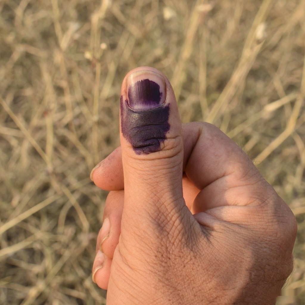 Illustrative close-up of a thumb stained with purple voting ink
